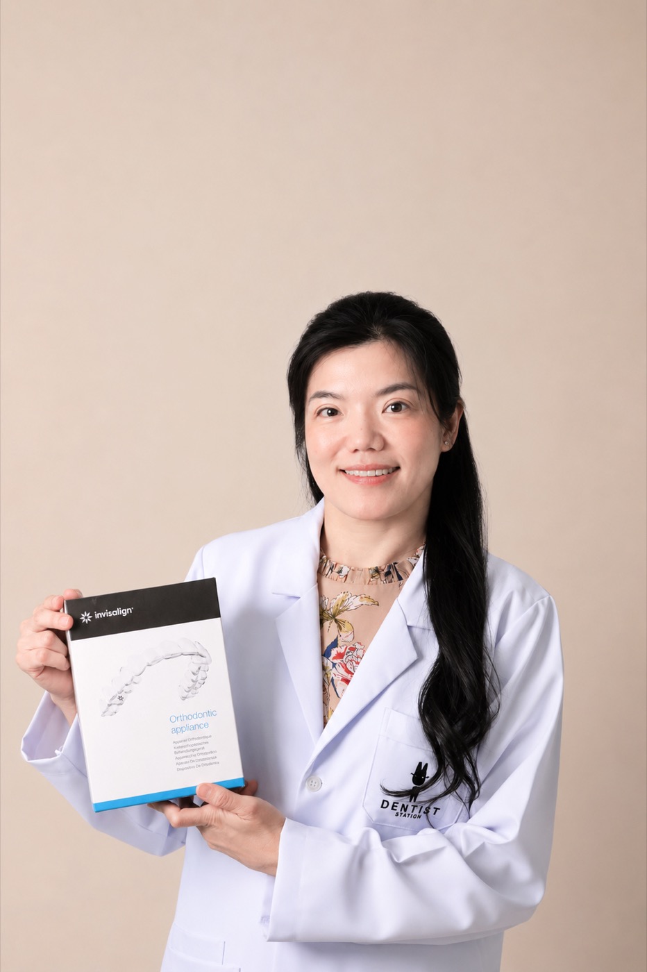หมอนิด ทพญ.ธานิสรีน สายสิทธิ์ ทันตแพทย์เจ้าของคลินิก ถือชุดจัดฟันใส Invisalign